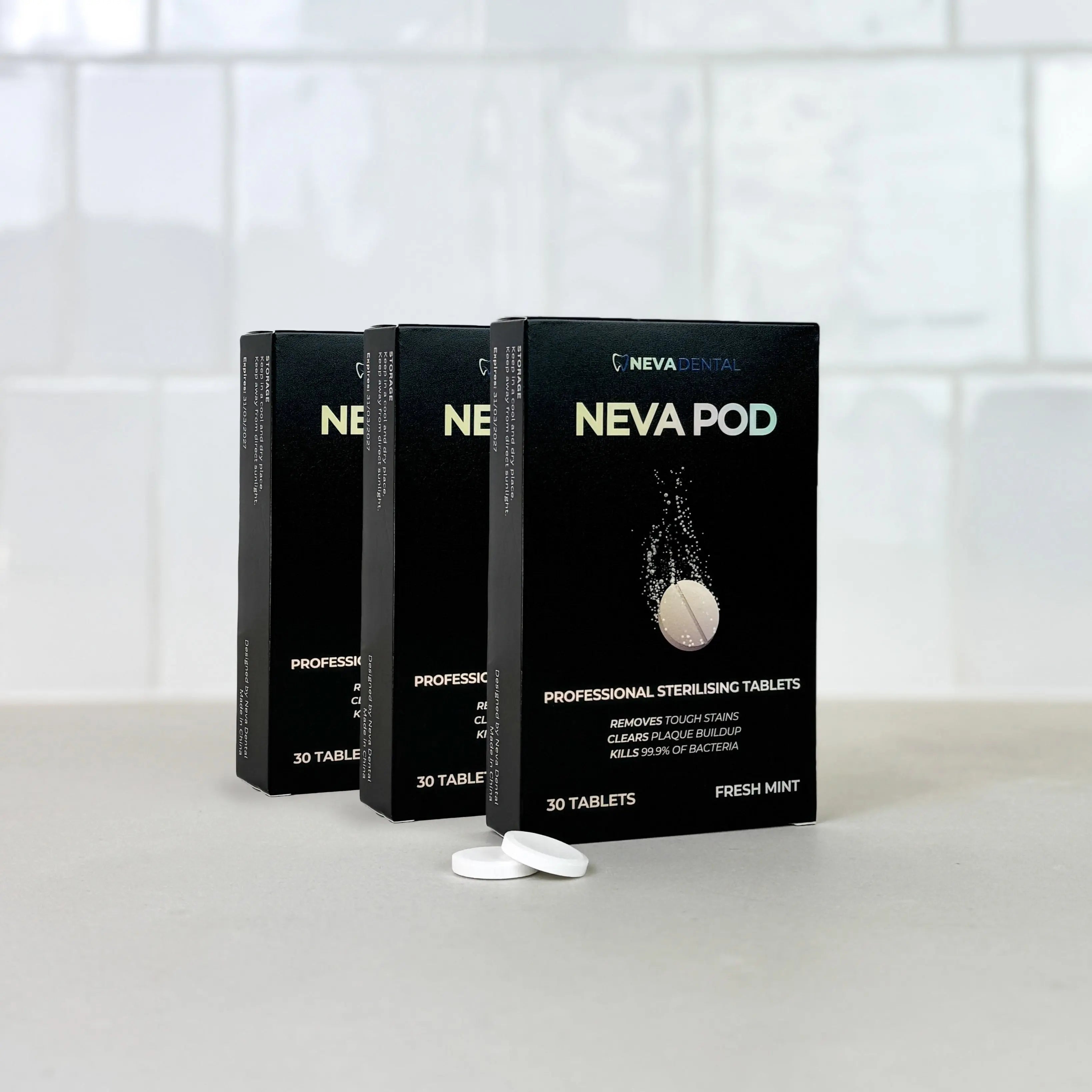 Three black 'Neva Pod' boxes on a white surface with a white tiled wall background.